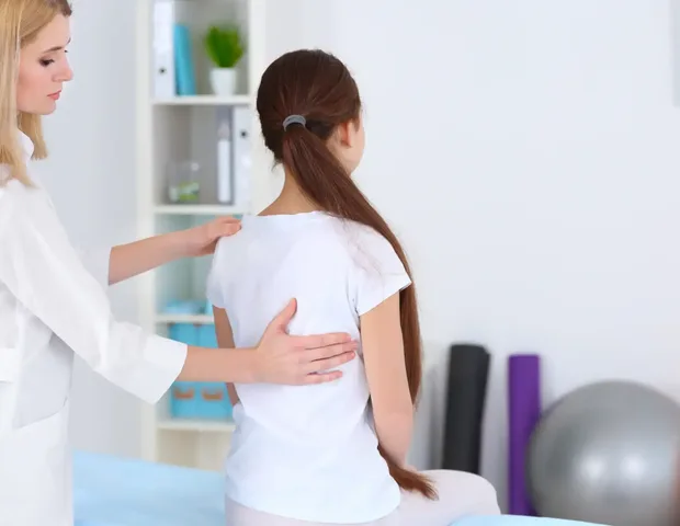 A clinician assessing a patient's posture and alignment