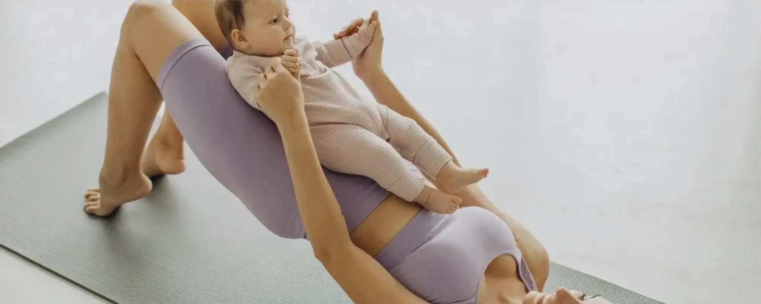 Mother with her baby practicing gentle postpartum exercise at home